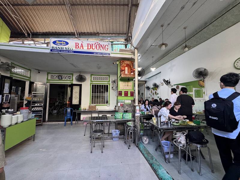 Gian ăn của quán Bánh Xèo Bà Dưỡng dưới tấm biển xanh đỏ