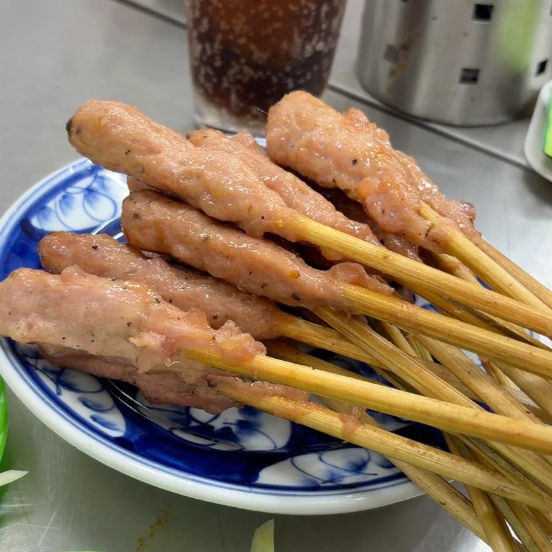 Nem lụi xiên que trên đĩa men xanh